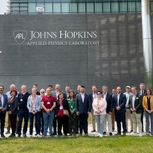 MPs  standing in front of a building with the sign John Hopkins Applied Physics Laboratory