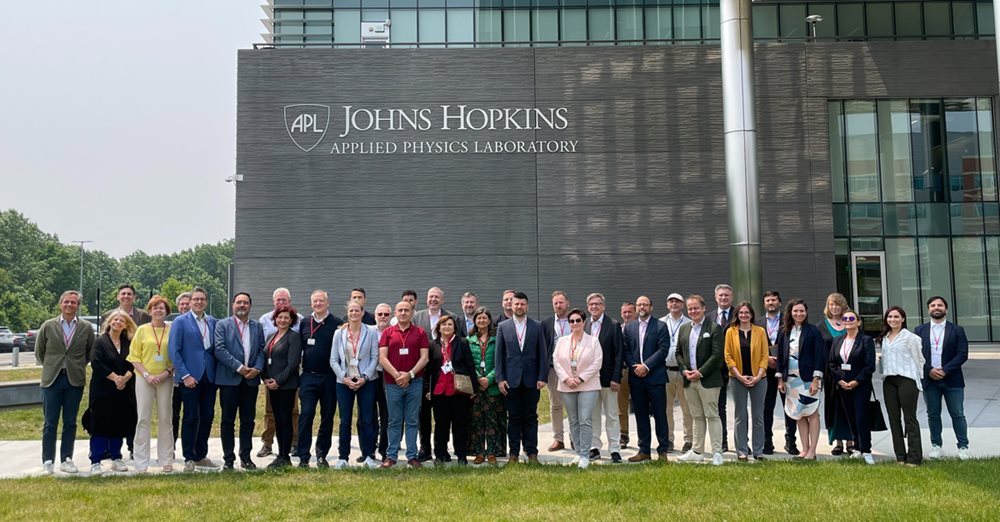 MPs  standing in front of a building with the sign John Hopkins Applied Physics Laboratory