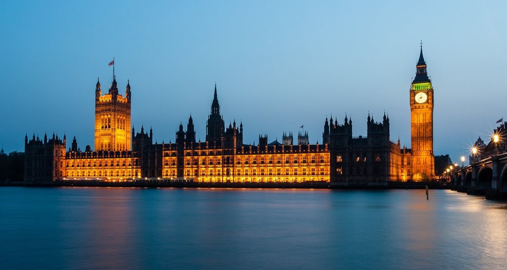 Houses of Parliament at night, lit up with the ruiver Thames in the foreground