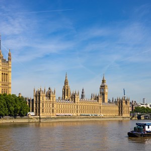 Palace of Westminster in the sunshine with the River Thames and a boat in the foreground