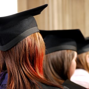 Three  university students wearing graduation gowns and hats