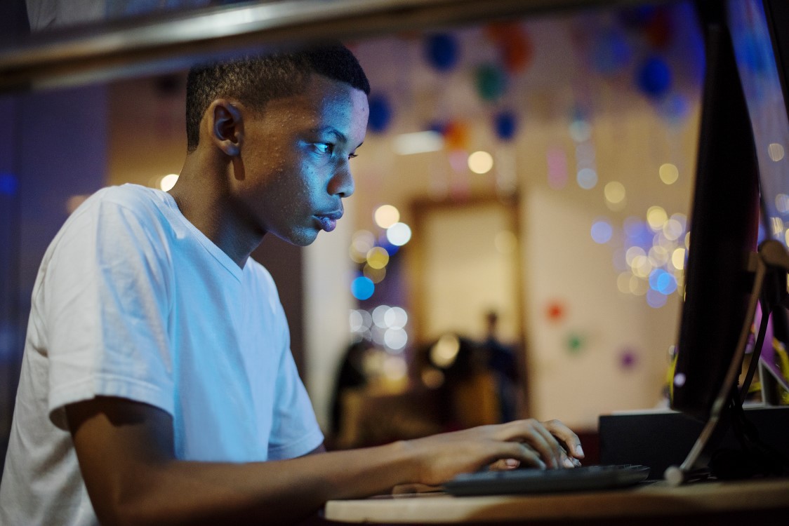 A teenage boy stares at a computer screen