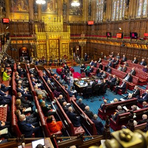 A busy House of Lords chamber with members sitting on the red benches