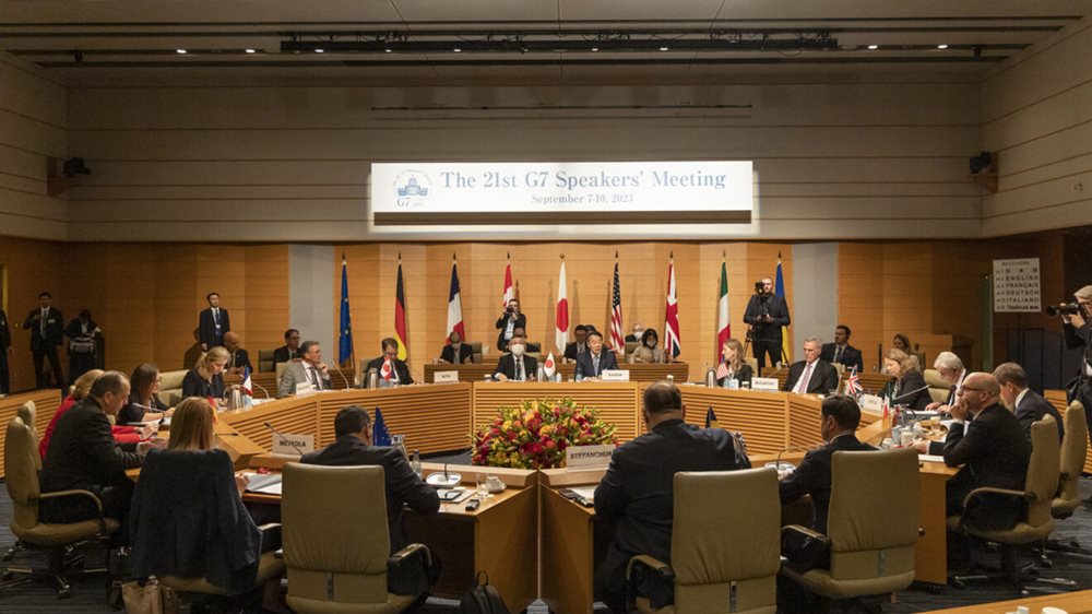 Speakers of the G7 sitting at a circular rtable under a banner  with the words The 21st G7 Speakers' Meeting