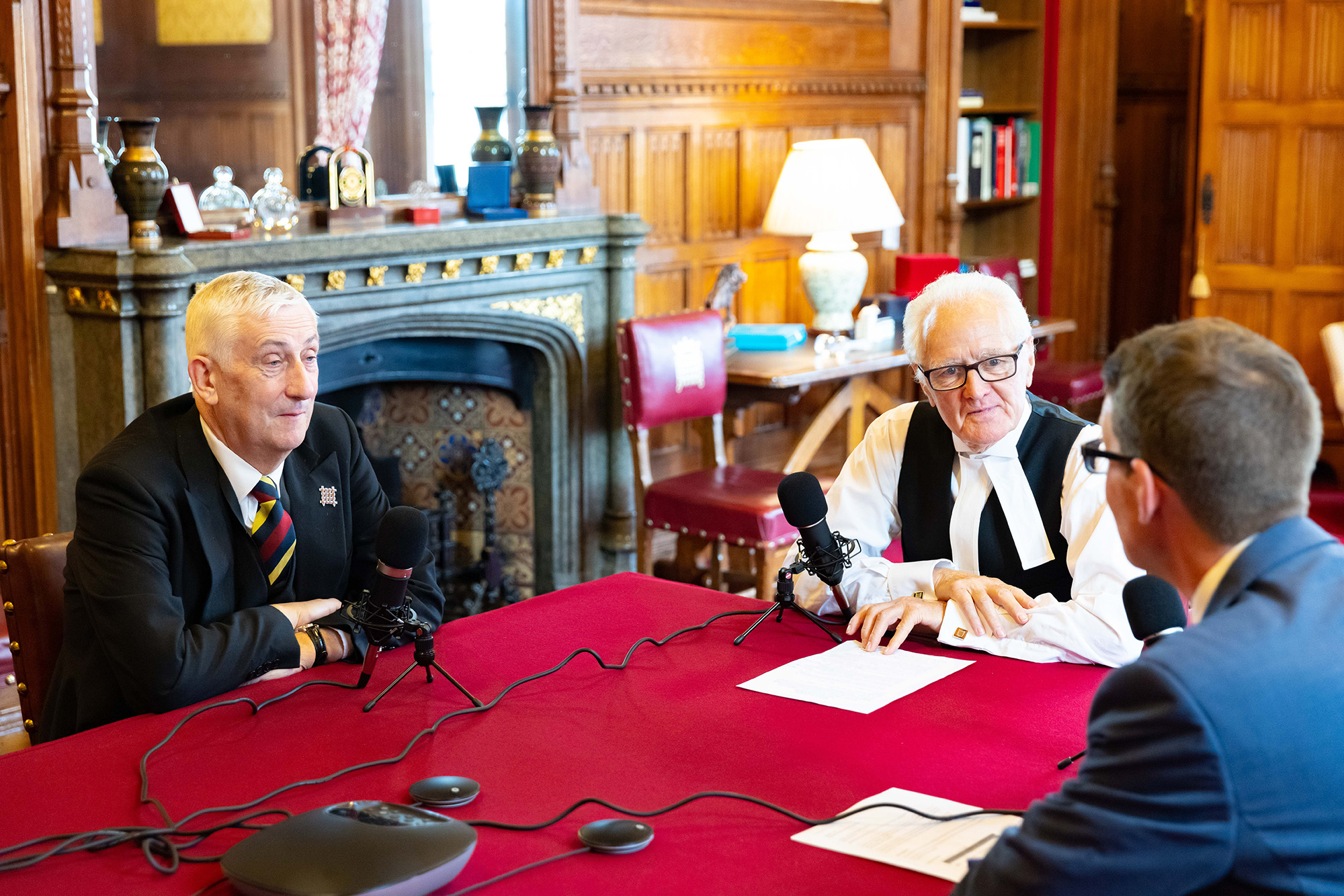 The Speaker of the House of Commons, Lord Speaker and podcast host Matthew Purvis sit around a table in front of microphones