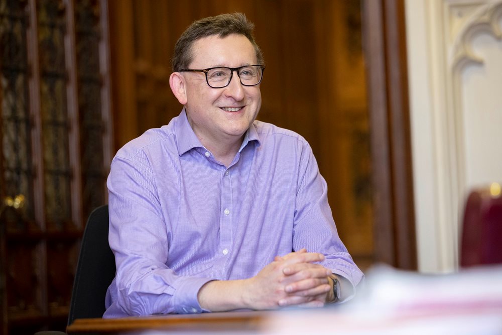 Photo of Simon Burton sat at a desk in the House of Lords