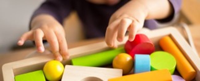 Image of a child's hands playing with toys